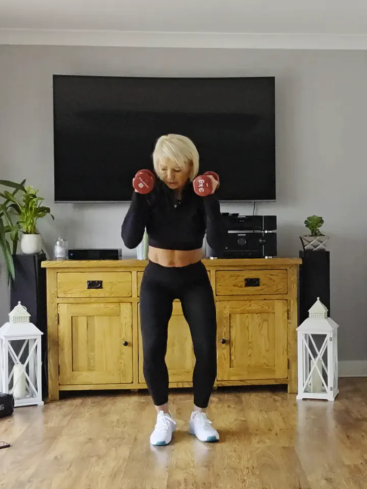 Anna in a wide squat with light dumbbells