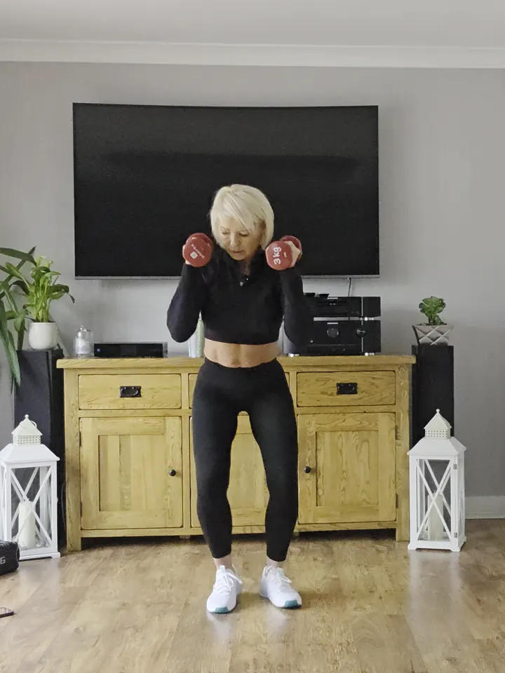 Anna in a wide squat with light dumbbells